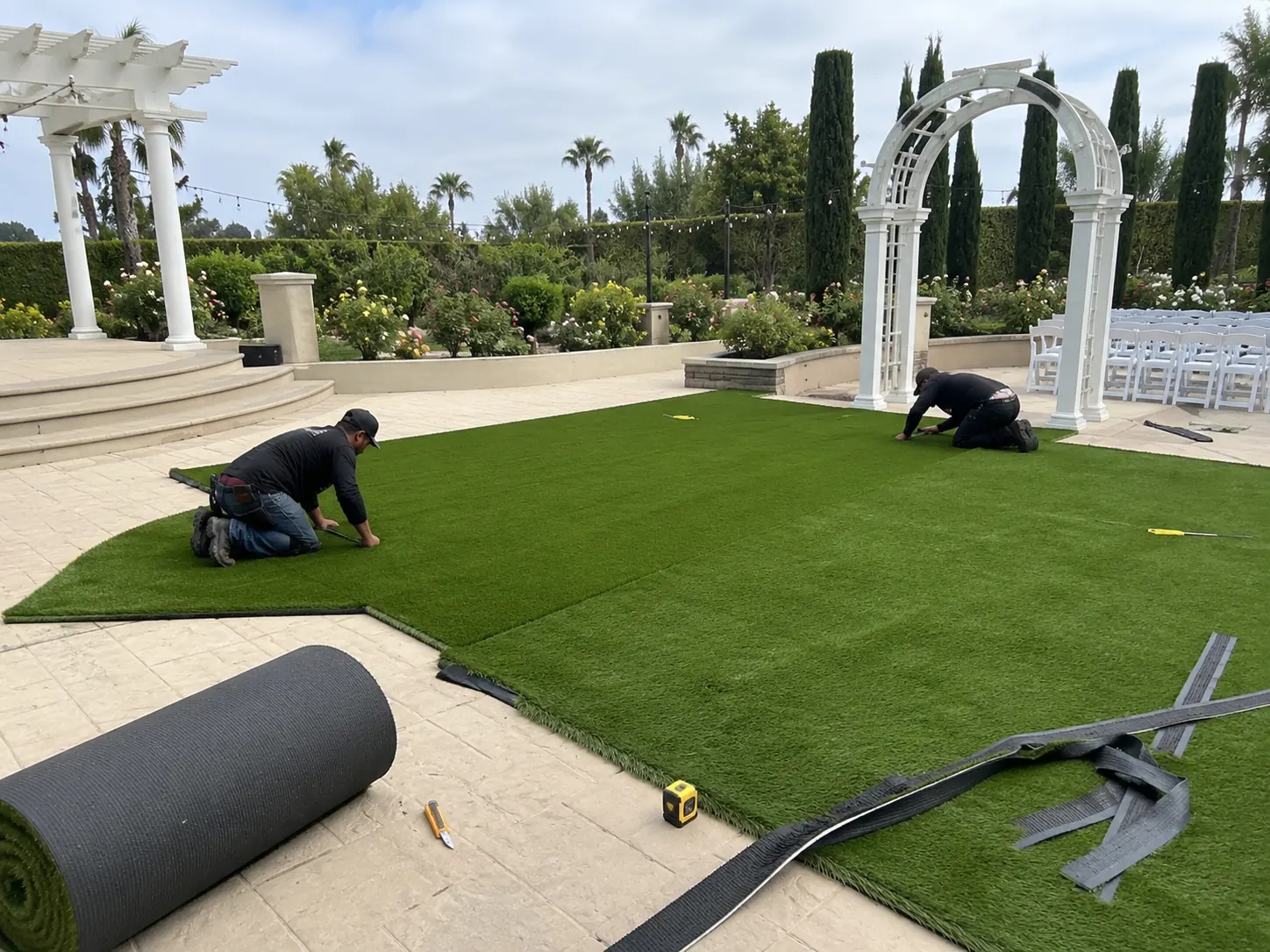 A vibrant green custom event turf installation laid out neatly across a modern trade show exhibition floor.