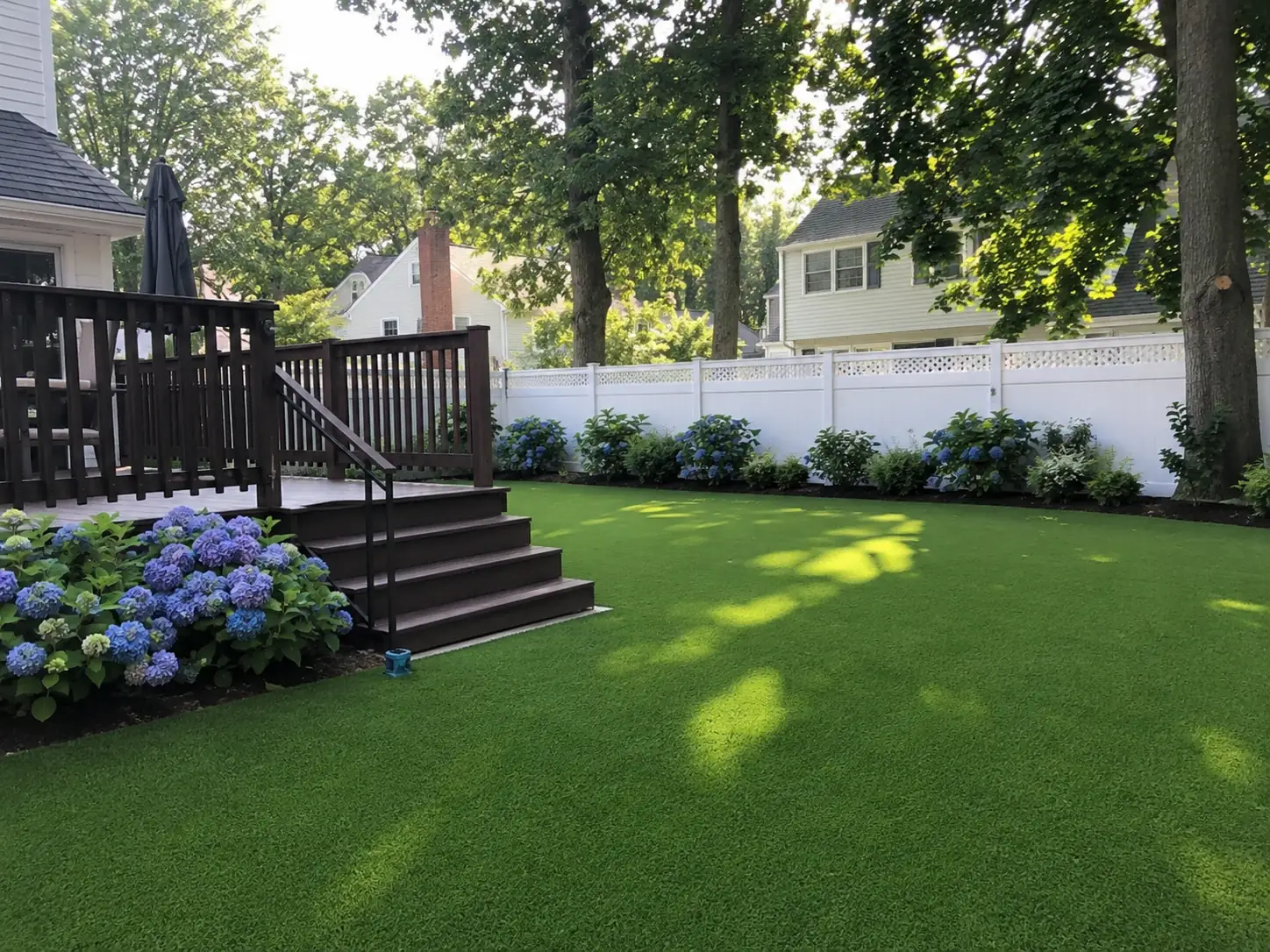 A pristine green artificial croquet turf installation featuring a smooth, short-pile playing surface in a private backyard.
