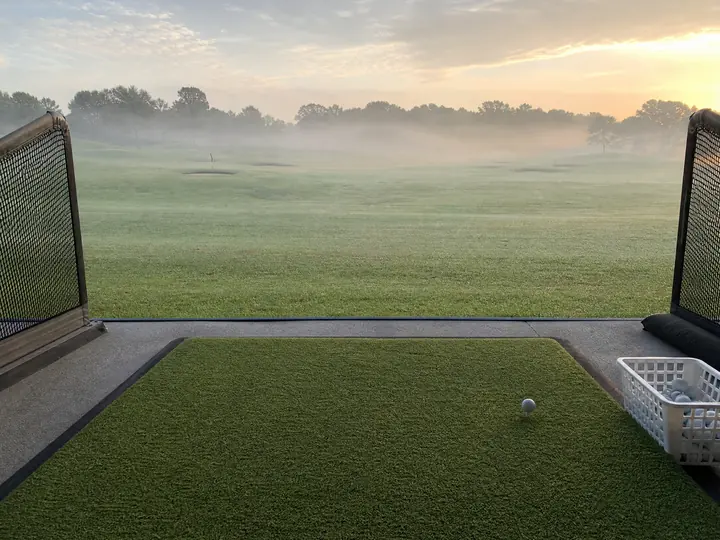 A professional artificial putting green and golf driving range featuring smooth turf and realistic practice stations.