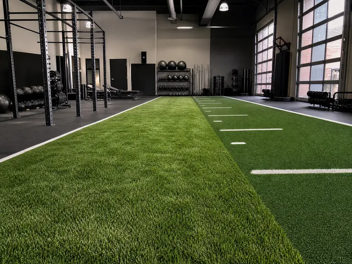 A professional sports training facility featuring durable hybrid turf installed across an indoor agility and conditioning field.